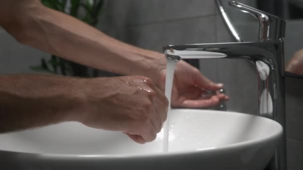 Lavarsi le mani per prevenire l'infezione da coronavirus Covid-19. L'uomo lava mani con sapone in lavandino a bagno moderno. Maschio è lavaggio e tornitura mani con schiuma — Video Stock