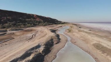 Adam Ukrayna 'nın Kuyalnik kıyısında bisiklet sürüyor. Kurumuş gölleri ve Kuyalnik haliçlerindeki çamur ile güzel sahil manzaralı hava aracı.