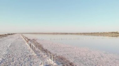 Kuyalnik haliçlerindeki eski ahşap direkli tuzlu sahil şeridi. Odessa yakınlarındaki Kuyalnik Liman sahilinde kristalize tuz. Eski ahşap yapılar, 18. yüzyılda tuz çıkarma.
