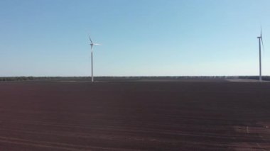 Rüzgârla dönen büyük bıçaklı yel değirmeninin havadan görüntüsü. Rüzgar türbini yeşil ekolojik yolla yenilenebilir enerji üretiyor. Alternatif enerji