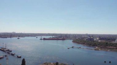 Limanı limana yakın kargo gemisi olan Chernomorsky Limanı. Metal konteynırlar, yüksek vinçler ve gemilerle Karadeniz limanının insansız hava aracı görüntüsü. Ukrayna sanayisi. Çevre kirliliği. Kargo teslimatı