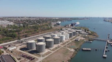 Karadeniz limanında tahıl, yakıt ve petrol için büyük metal konteynırlar. Chernomorsky Limanı 'nın limana yakın kargo gemileriyle insansız hava aracı görüntüsü. Ukrayna sanayisi. Çevre kirliliği. Kargo teslimatı