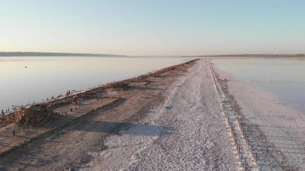 Luchtfoto van Kuyalnik Estuarium met zout en oude houten palen op zonnige dag en goed weer. Uitzicht op estuariumkolommen, zout zand en roze water op Kuyalnik Liman, Odessa, Oekraïne — Stockvideo