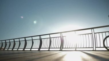 Kasklı genç bir bisikletçi gün doğumunda yaya köprüsünde bisiklet üzerinde pedal çeviriyor. Dişi hippi bisikletli gün batımında sahil kenarında bisiklet sürüyor. Bisiklet kavramı