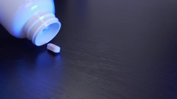 Dokter ilmuwan menuangkan pil putih dari tabung dengan latar belakang hitam. Narkoba tumpah dari botol di atas meja. Industri Farmasi. Ya. Vaksin Coronavirus — Stok Video