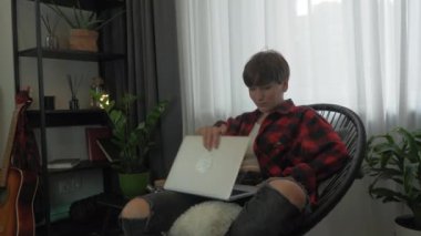 Kadın dizüstü bilgisayarı açıyor ve merkez ofiste rahat bir sandalyede çalışmaya başlıyor. Odaklanmış kadın çalışanın portresi evden bilgisayarla uzaktan kumandayla çalışıyor. Kişisel izolasyon