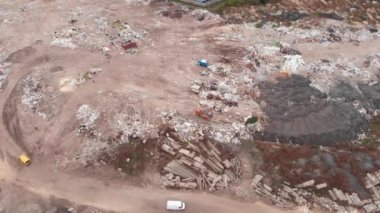 Çöp yığını. Buldozer araziye enkaz yığıyor. Çöp kamyonundan inşaat atığı dökülüyor, hava manzaralı. Çevresel olarak tehlikeli toksik atık. Ekolojik kirlilik sorunu