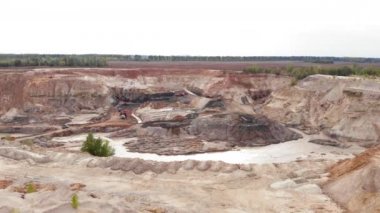 Mineraller çıkarılmış dev bir taş ocağı. İnsansız hava aracı kum üzerinde ya da ağır makinelerle kil ocağında uçuyor. Açılmış maden ocağı endüstrisi ve bir sürü makine çalışıyor. Demir cevheri veya bakır özütü