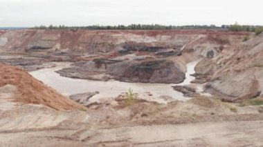 Clay Quarry, hava manzaralı. Açık maden işletmeleri. Açık maden madeni. Makineler çalışıyor. Ekoloji ve madencilik endüstrisi. Dünya kaynakları