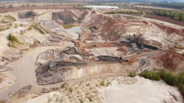 Demir cevheri, kil, taş ve minerallerden oluşan devasa bir endüstriyel taş ocağı. Makine kamyonları ve kazıcılar büyük bir maden ocağında çalışıyorlar. Madencilik endüstrisi