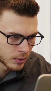 Ofiste dizüstü bilgisayara bakan üzgün bir adam. Mutsuz erkek bilgisayar ekranında kötü haber okuyor. Dikey