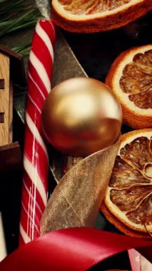 Mum, Noel süslemelerine karşı yanıyor, yakın. Mumla süslenmiş güzel bir Noel masası. Yeni yıl ve Noel kutlaması. Dikey video