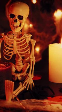 Korkunç ürkütücü cadılar bayramı arkaplanı. Cadılar Bayramı süsü. Cadılar Bayramı partisini kutluyoruz. İskelet ve yanan mumlar cadılar bayramı arka planında. Dikey video