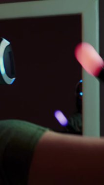 Sanal gerçeklik kulaklıklı kız joystick kullanarak çizgiler çiziyor. Kadın evde VR gözlüğü kullanarak oyun oynuyor. Dikey video