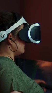 Sanal ya da artırılmış gerçeklik gözlüğü kullanan, etkileşimli oyunlar oynayan bir kız. VR eğlence konsepti. Sanal gerçeklik kaskı. Dikey video