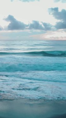 Güçlü deniz dalgaları su yüzeyine sıçrıyor ve sahile çarpıyor. Denizde rüzgarlı ve fırtınalı bir hava. Şiddetli azgın deniz. Dramatik okyanus. Dikey video