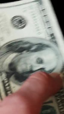 Erkek ellerinin para saymasını engelle. Dikey video. Adam dolarları sayıyor. Para hesaplaması. Nakit para ödemesi. Amerikan para birimi değişimi