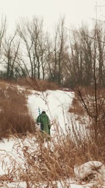 Kış balıkçılığı. Buz matkaplı balıkçı kış balıkçılığına gidiyor. Dikey video