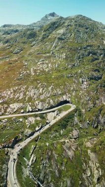 İsviçre Alpleri 'ndeki Grimsel dağ geçidi boyunca giden araba yolu. Dağ geçidinde asfalt yol boyunca giden arabalar. Dikey video