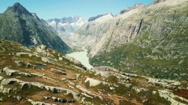 Dağ manzarası, kayalık dağ zirveleri ve göl. İsviçre Alplerinde Grimselsee 'nin hava görüntüsü