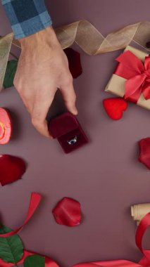 Erkek, Sevgililer Günü 'nde bir kadına evlilik yüzüğü verir. Erkek, Sevgililer Günü 'nde kadına evlenme teklif ediyor. Kadın nişan yüzüğünü dekore edilmiş masa arkasına takıyor. Dikey video