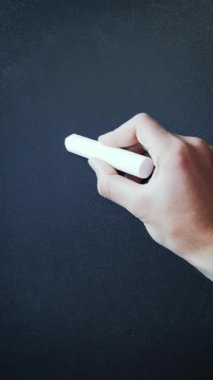 Profesör tahtaya tebeşirle yanlış matematik formülü yazıyor. El, tahtaya basit aritmetik matematik denklemi yazar. İki artı iki, okul yönetim kurulunda yazılı beş eder. Dikey video