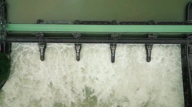 Hidroelektrik santralindeki açık kapılar ve büyük su akışının üst görüntüsü. Su barajının havadan görünüşü ve çağlayan su damlaları