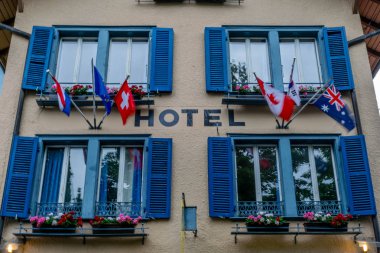 Interlaken, İsviçre'de jalousie, çiçek tarhları ve bayraklarla güzel otelin ön cephesi