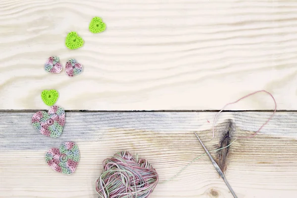 かぎ針編みの木製の背景に異なる色の心 針仕事の概念 バレンタインの日 — ストック写真