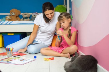 Kızım ve anne renkli kağıttan figürler yapıyoruz, yakın bir kedi uyuyor