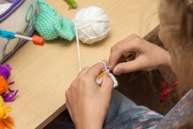 Kız örgü örer ipliklerden Masada oturan