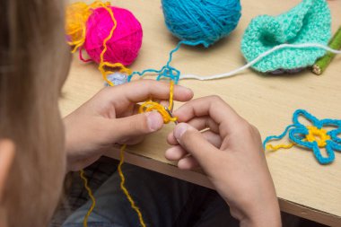 Bir çocuğun elleri kancayla ipliklerle işlenmiş.