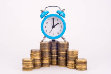 Saat bozuk para yığınının üzerinde.