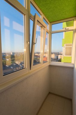 Çok katlı bir apartmanın dairesinde küçük camlı bir balkon.