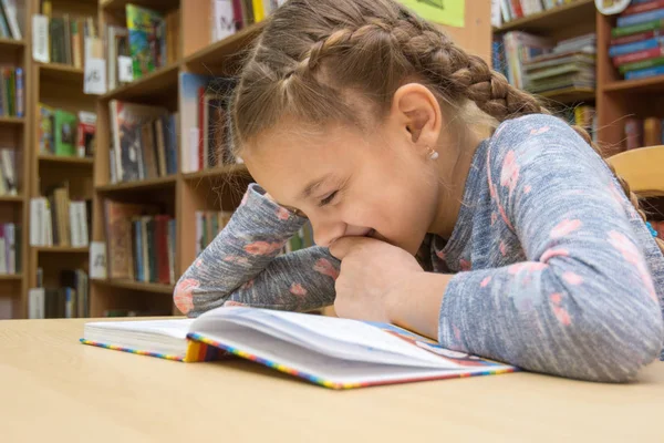 Mädchen Lacht Beim Lesen Eines Buches Der Bibliothek — Stockfoto