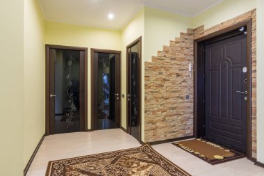 Dairede geniş bir giriş salonu, odanın üç kapısı, banyo ve tuvalet.