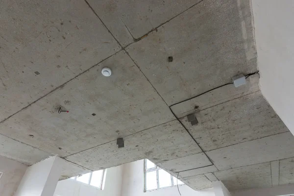 Бетонный потолок в новом здании, датчик огня — стоковое фото