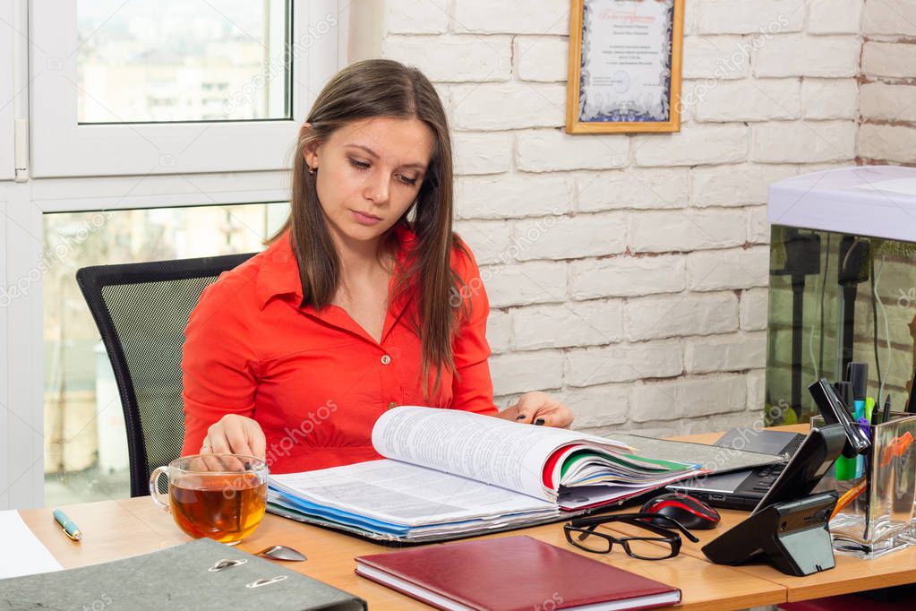 An office employee scrolls through documents in a folder