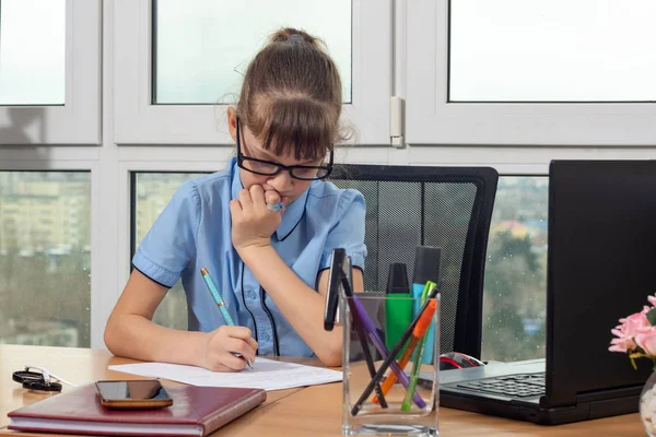 Osmiletá holka u stolu v kanceláři zamyšleně napíše pero na list papíru. — Stock fotografie