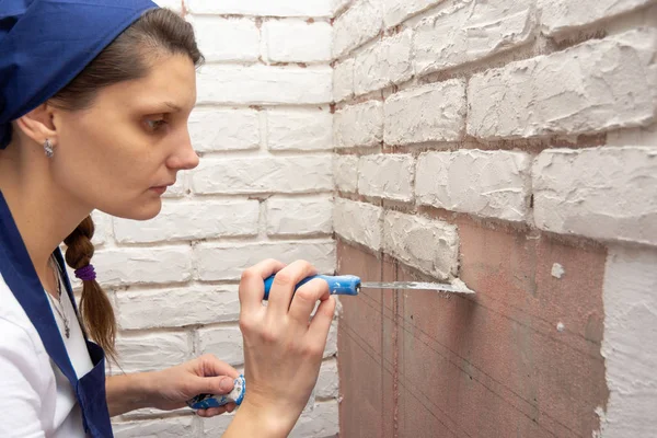 Girl plasterer lays on the wall with plaster imitation brickwork — Stock Photo, Image