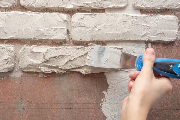 Plasterer arbetar manuellt med en spatel och jämnar ut på väggen — Stockfoto