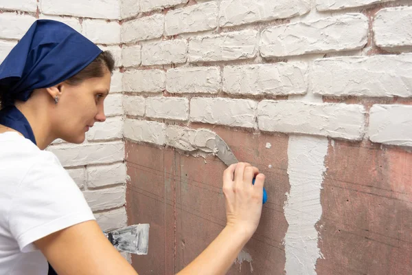 Plasterer girl makes designer author's imitation of brickwork on the wall of an apartment — Stock Photo, Image