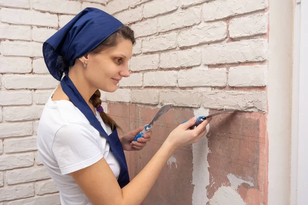 Plasterer girl forms from a plaster mass bricks on the wall — Stock Photo, Image
