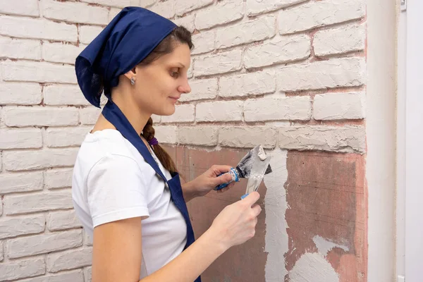 Plasterer girl plasters a wall, laying out imitation brickwork — Stock Photo, Image