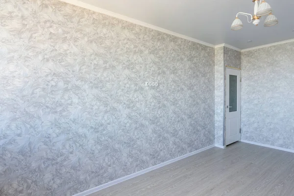 Interior of an empty renovated room, a TV is hanging on the wall