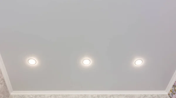 Fragment of the stretch ceiling with three spotlights in a row — Stock Photo, Image