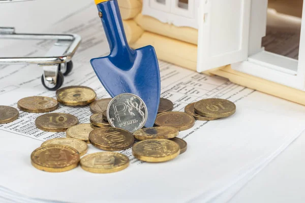 Υπάρχει ένα νόμισμα Ρούβλι στον ώμο, δίπλα στους λογαριασμούς για το διαμέρισμα και το σπίτι παιχνίδι — Φωτογραφία Αρχείου