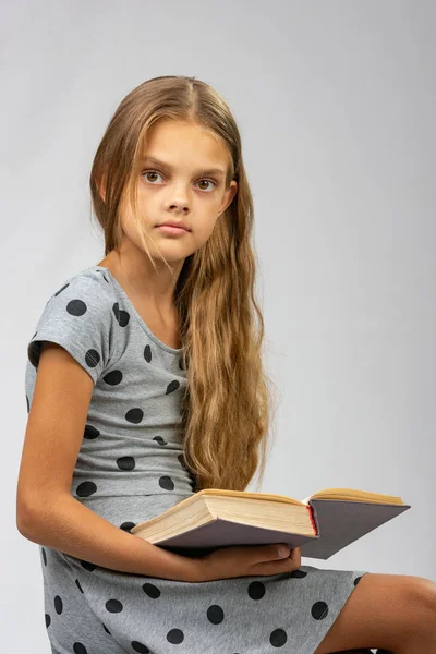 Une fille de dix ans s'est détournée de la lecture d'un livre et a regardé le cadre — Photo