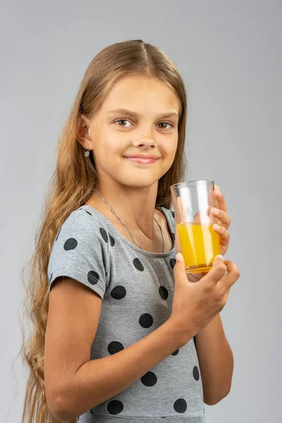 Das Mädchen hält stolz ein Glas Saft in der Hand — Stockfoto