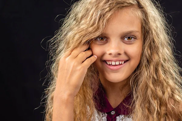 Retrato de uma menina de dez anos sorrindo amplamente com cabelo louro encaracolado — Fotografia de Stock